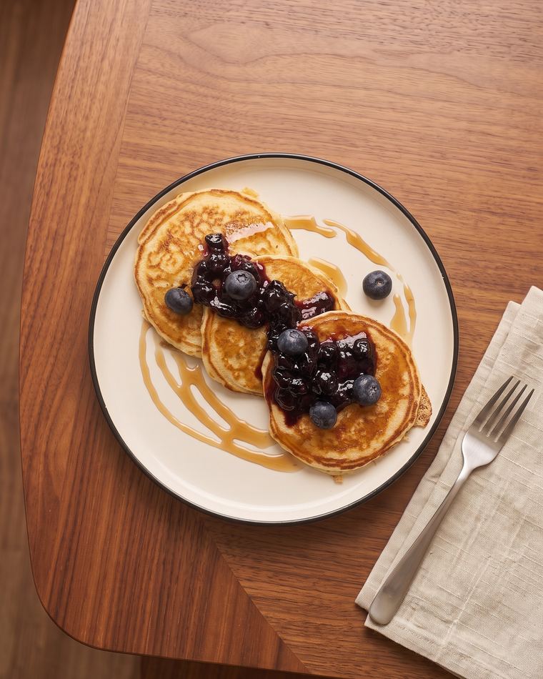 White chocolate chip pancakes with blueberry compote and maple syrup